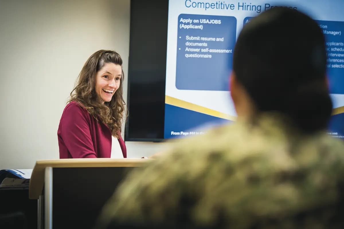 A counselor smiling while walking a service member through the federal hiring process